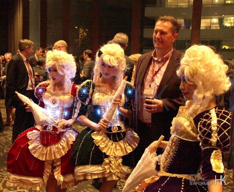 Three  model dancers in period attire taking picture with business men
