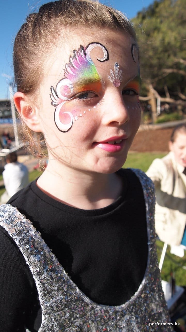 Lovely rainbow face paint form a great face painter in HK at a Hong Kong corporate funfair