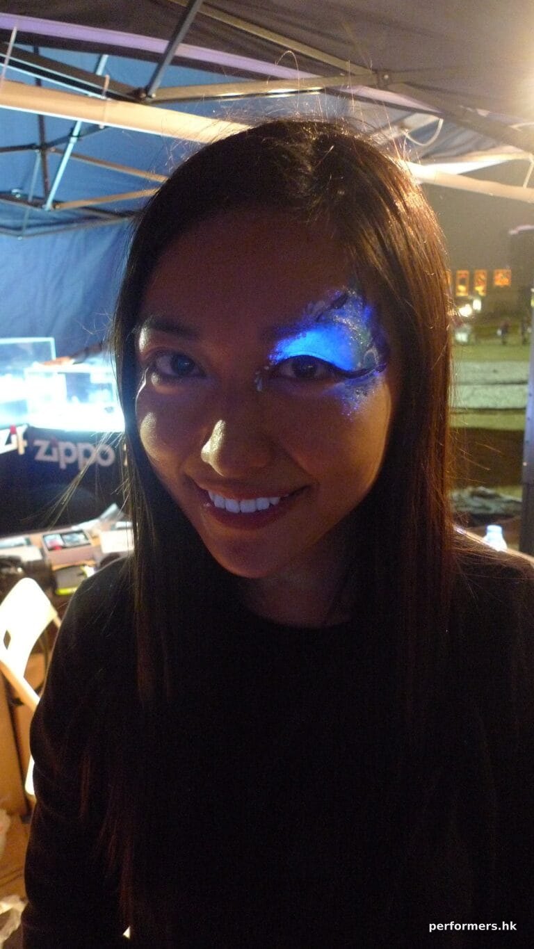 Girl with glow in the dark eye face paint.