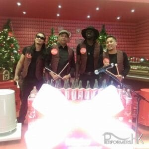 Four trash / bottle drummers have photo taken in front of the props