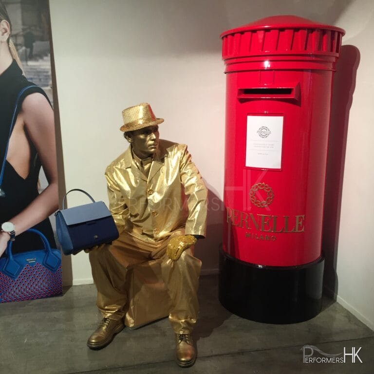 Living Statue holding handbag sitting next to red post box in hong kong