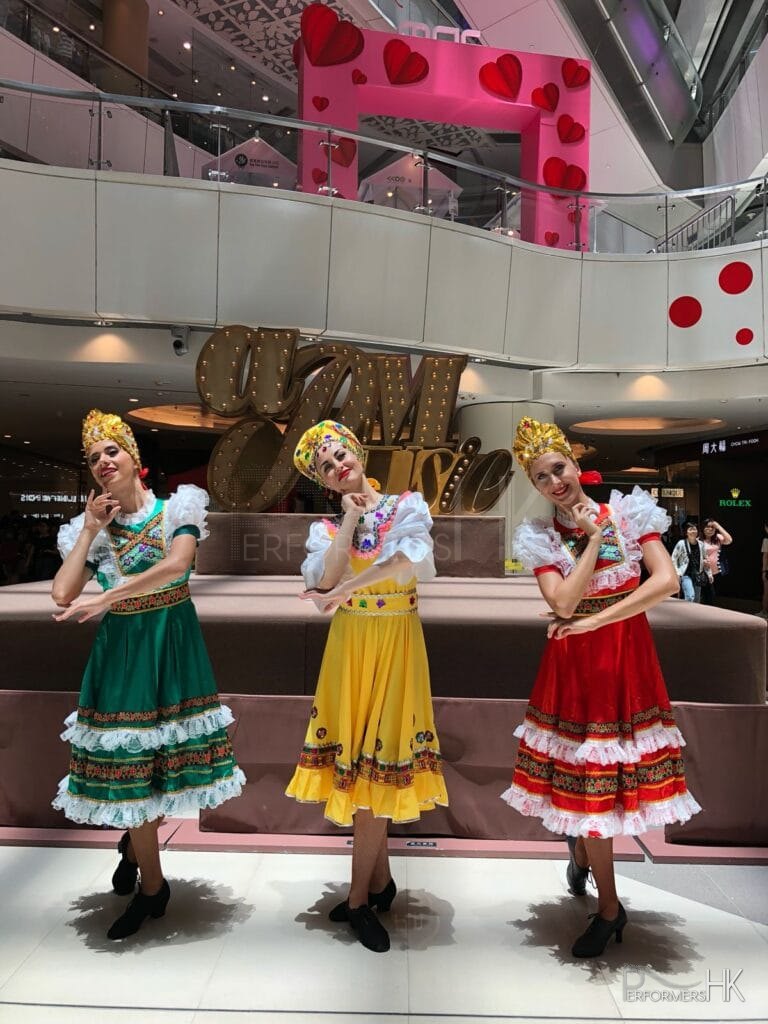 3 girls in different color costumes doing russian folk dance