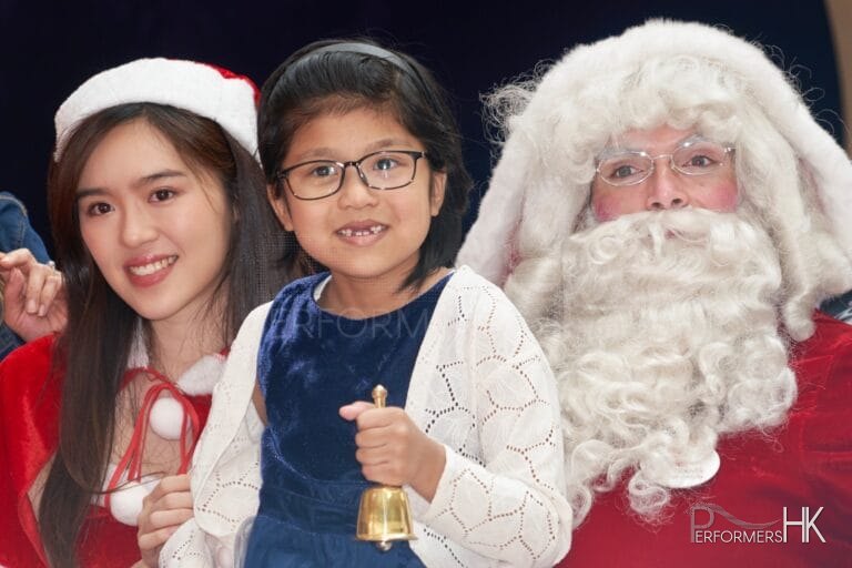 child holding bell in blue top with santa performer from performers hk