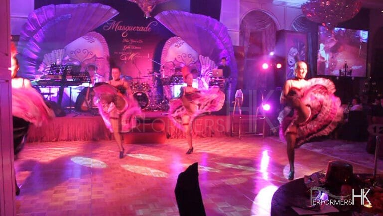 dancers performing kicks in purple backdrop at a ball