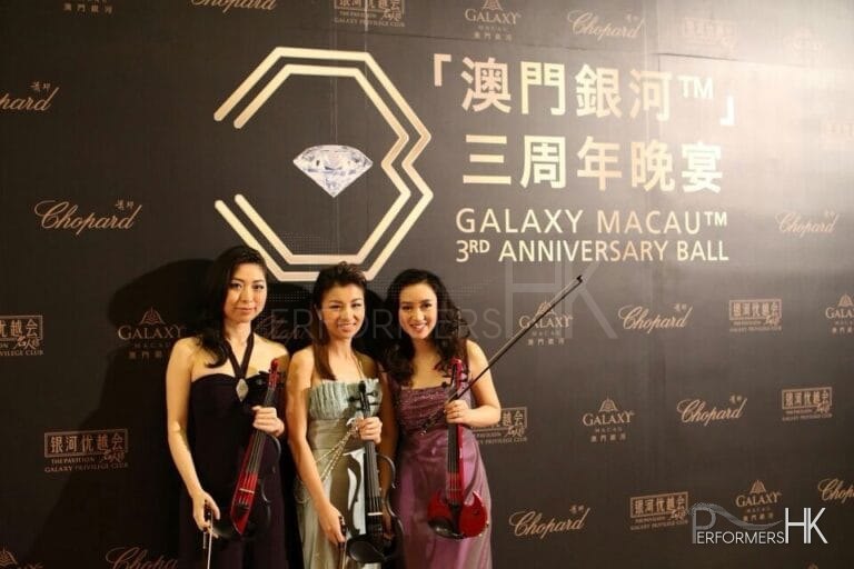 Violinists in Hong Kong taking photo in front of the backdrop before the Galaxy Macau 3RD Anniversary Ball start