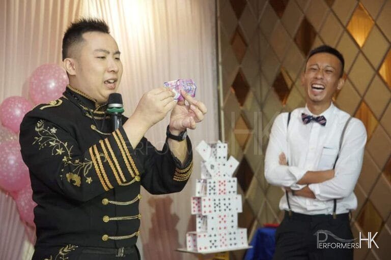 Magician tearing up money with guest laughing by his side