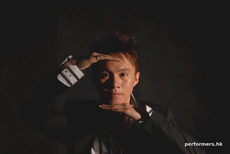 Hong Kong Magician head shot holding his hands in front of his forehead and chin