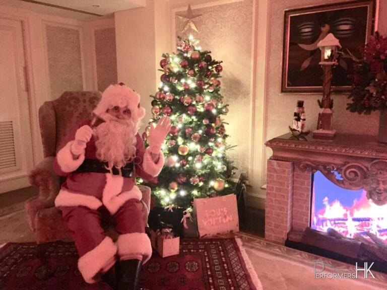 Santa sitting in front of fire place at American club tai tam event in Hong Kong