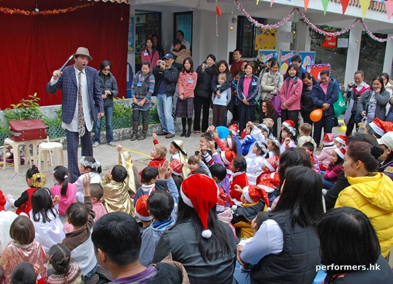 The juggler asking for a volunteer and a lot of the audience putting their hands at a Hong Kong Christmas event