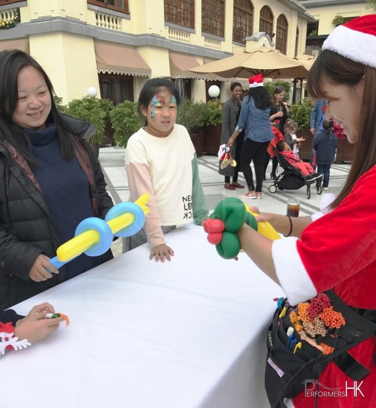 genie balloon twister in red lady santa costume at 109 repulse bay twisting balloons for patrons