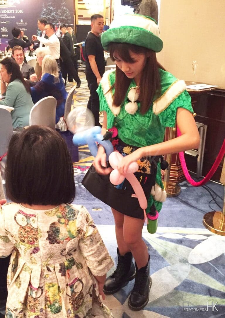 balloon twister genie in green elf costume twisting balloon for child at shangri la hong kong central