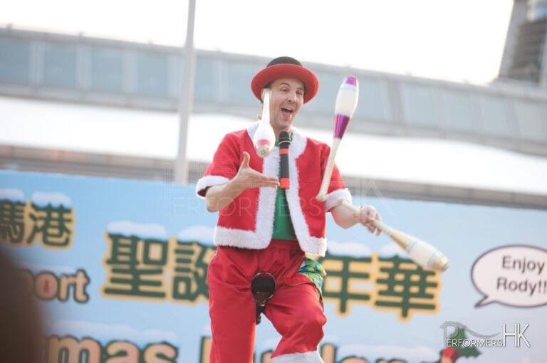 Unicyclist performing three cups juggling on the unicycle at Hong Kong Shopping center corporate Christmas Carnival event