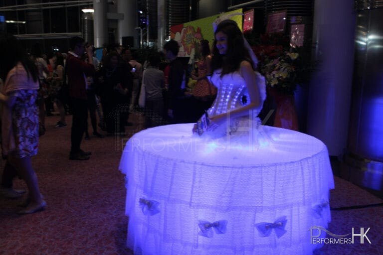Model dressed in LEd lights and standing in the middle of a table
