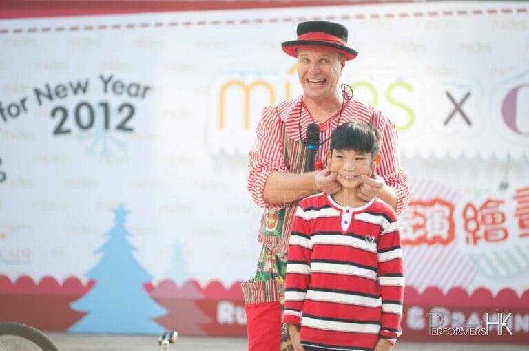Clown show with performer making a small child smile