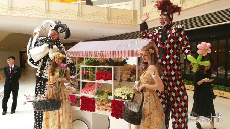 Stilts walkers standing next to flowers