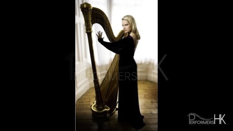 A HK harpist wearing a black dress posing next with the harp for a wedding
