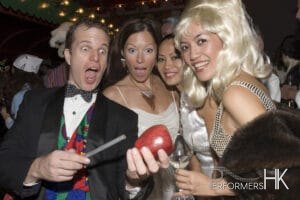 Walk around magician in Hong Kong performing roving magician with apple to a lady holing a glass of wine at a corporate cocktails event