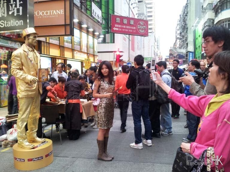 Promotion girl with Golden statue standing on box
