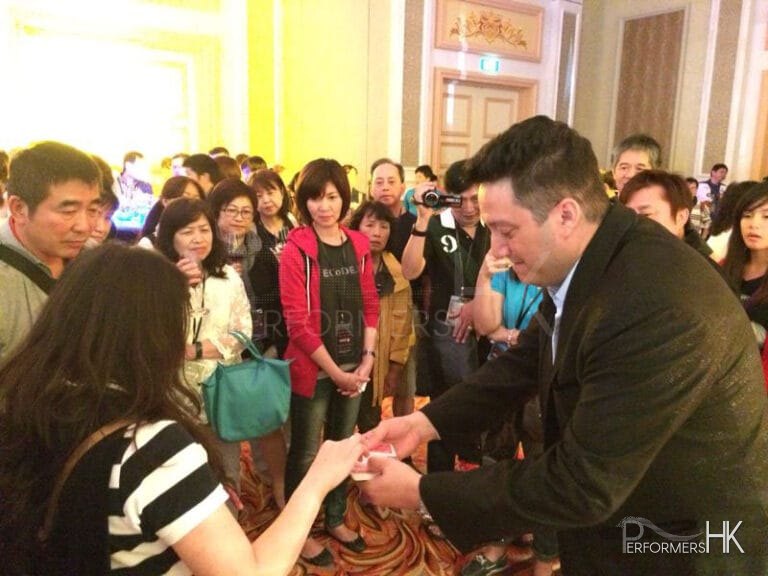 Walk around magician performing close up card magic and invited a guest to pick a card at a cocktails party in Hong Kong