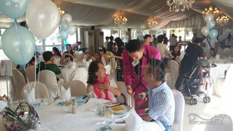 Roving Magician performing table magic with cards to a couple for a corporate event at Hong Kong Aberdeen marina club