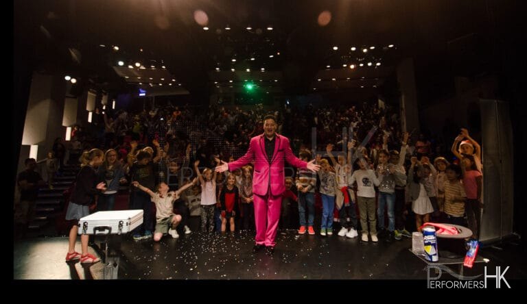 Hong Kong stage magician taking a picture with his audience after his performance at a corporate children event