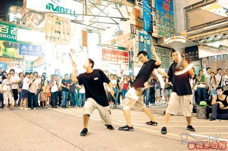 Three fire juggler performing a combined fire show in Hong Kong Causeway Bay
