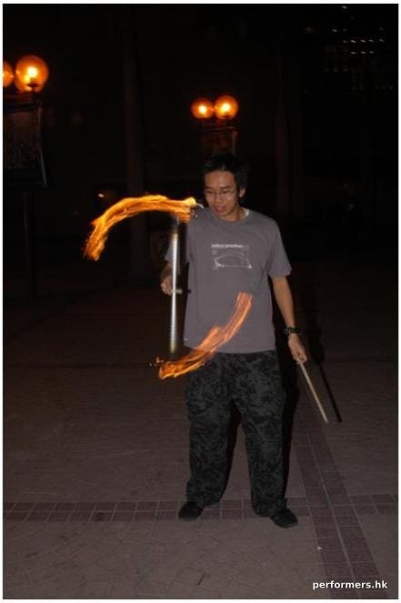 Hong Kong fire juggler performing with the fire devil stick at a corporate event