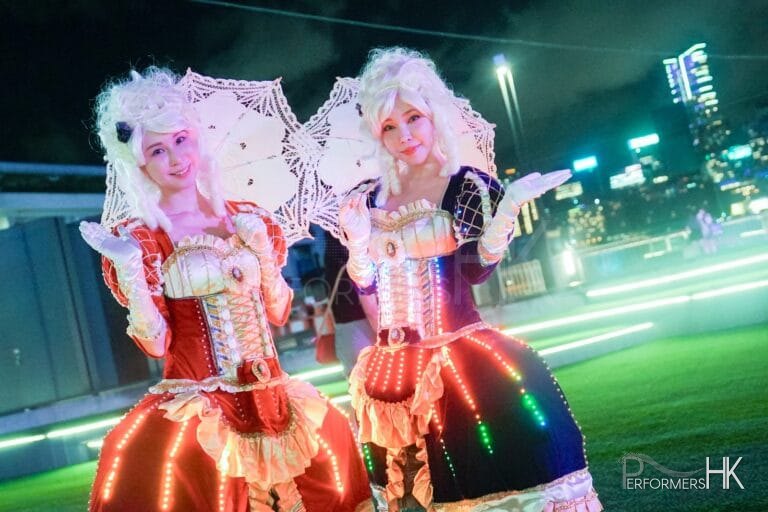 two led costume character at hong kong harbour front in july for the hktb festival with parasols and in led costume one in red and another in purple