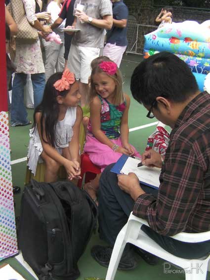 Caricaturist drawing two little girls