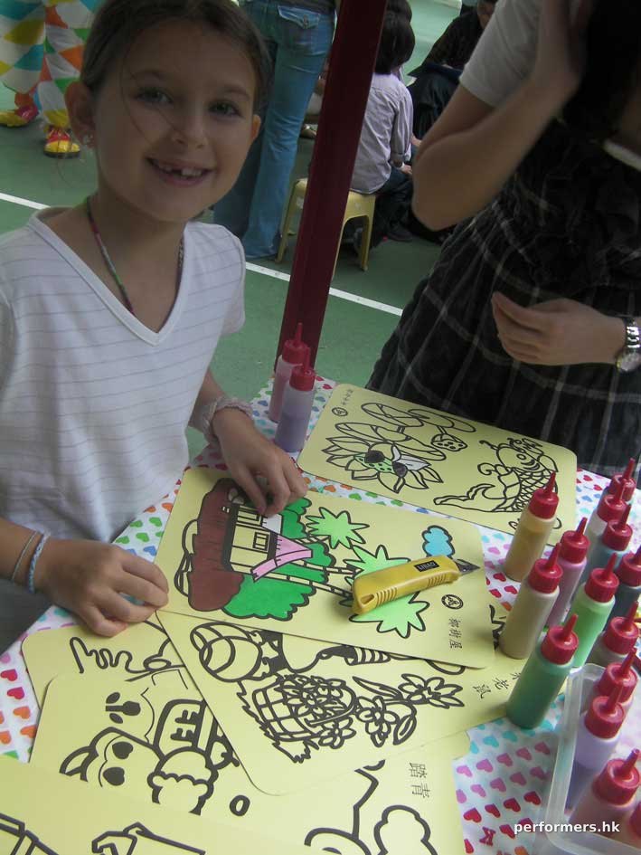 A girl in HK is creating her very own artwork at a corporate school event