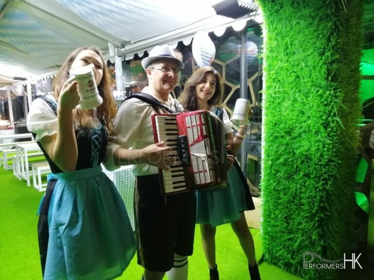 Accordion player in oktoberfest laderhosen with two models in tradtional bavarian beer girl costume at Ritz hong kong
