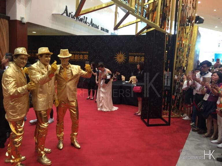 Three statues performers posing at a corporate event open ceremony