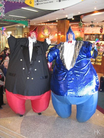 Stilt walker in inflatable fat formal attire costume at a cafe in Hong Kong