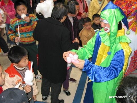 Hong Kong roving clown performer making a balloon for the little guest at a corporate family day event.