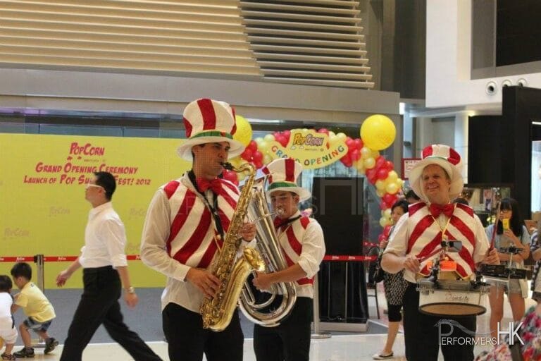 Three strolling musicians wearing colorful candy cane vests in a mall