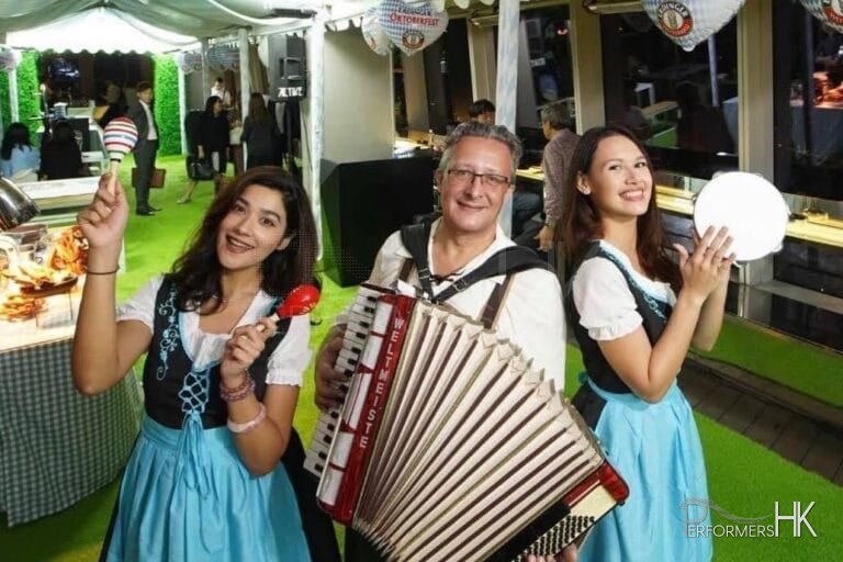 Solo accordionist playing music with 2 models wearing traditional german beer girl costume
