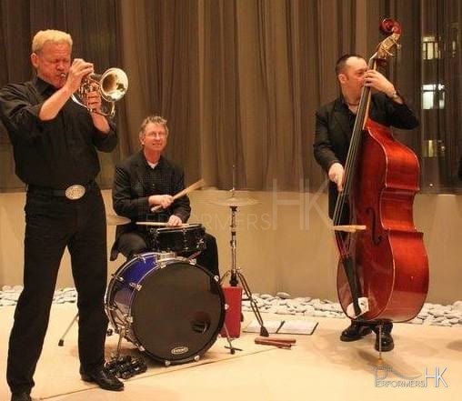 Three live band musicians performing at a Hong Kong realistic opening event
