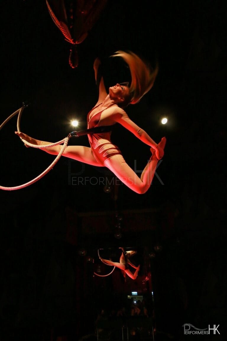 Aerial Solo Hoop performer during beautiful movement with the hoop in the midair at a corporate annual dinner.