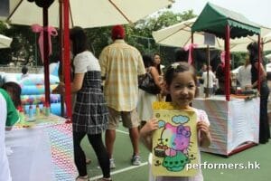 A little girl showing off her sand art work at a Hong Kong school event
