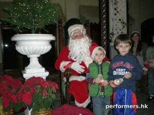 Professional Santa in HK greeting and taking picture with the kids at a Christmas event.