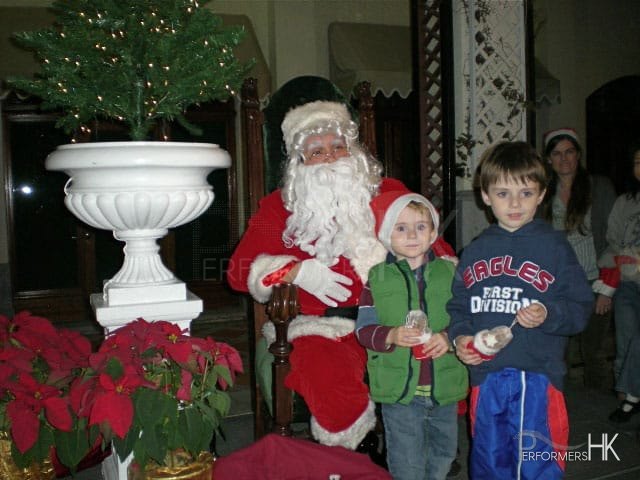 Professional Santa in HK greeting and taking picture with the kids at a Christmas event.