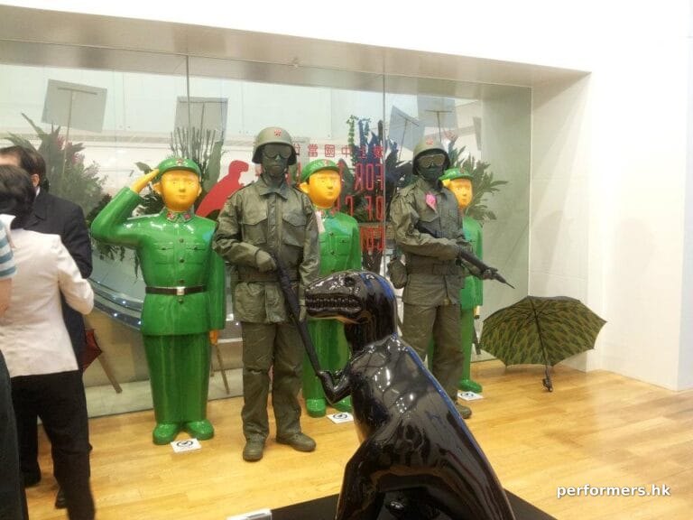 Two toy solder living statues staning next to three green army at a Hong Kong store opening event