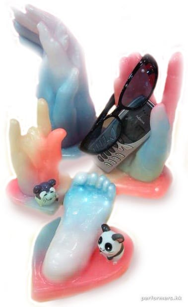 Wax hand holding a mobile phone and sunglassesand a wax child hand and a wax baby foot
