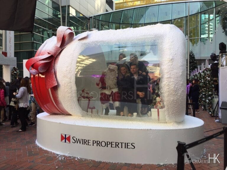 Santa performer inside a large glass jar