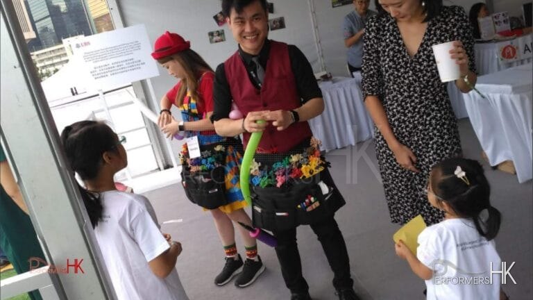 Balloon artist creating colorful balloon sculptures for guests at a corporate event