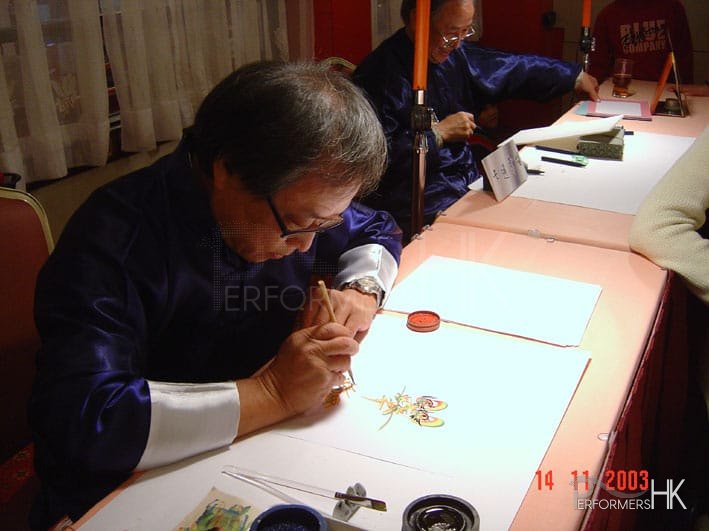 artist in hong kong wearing blue top drawing rainbow calligraphy